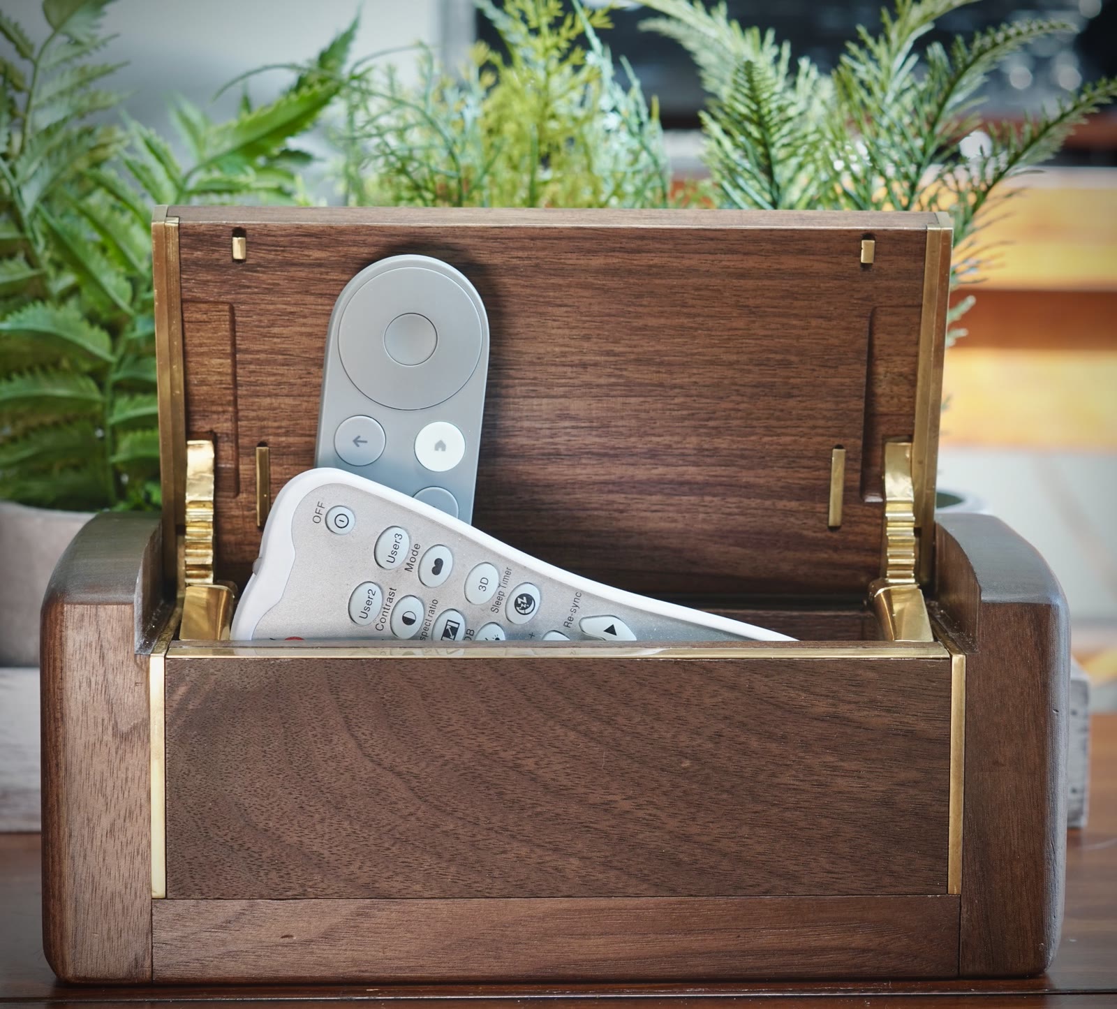 The Detox Box on a desk, brass-lined walnut, a phone being placed inside
